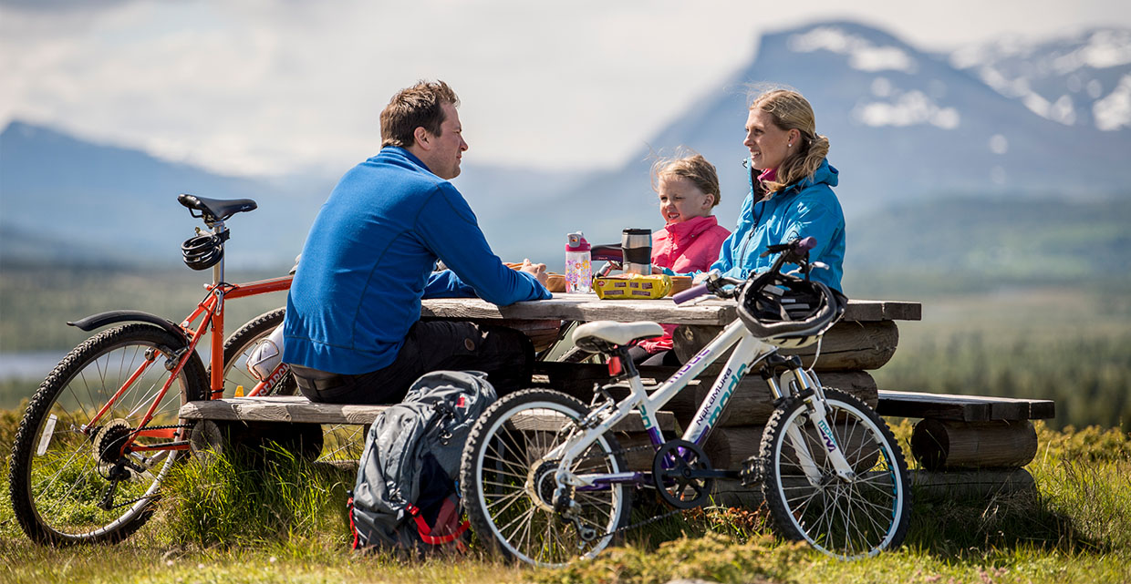 A family with bicycles is taking a rest at a bench